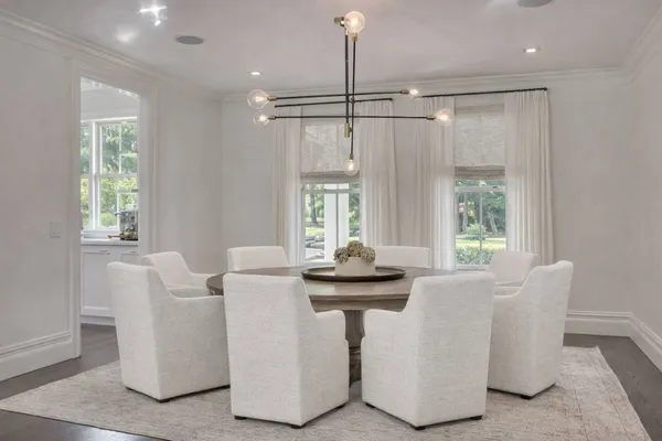 a dining table chairs and window in a room
