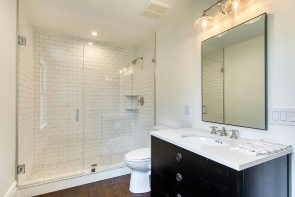 a bathroom with a double vanity sink toilet and shower