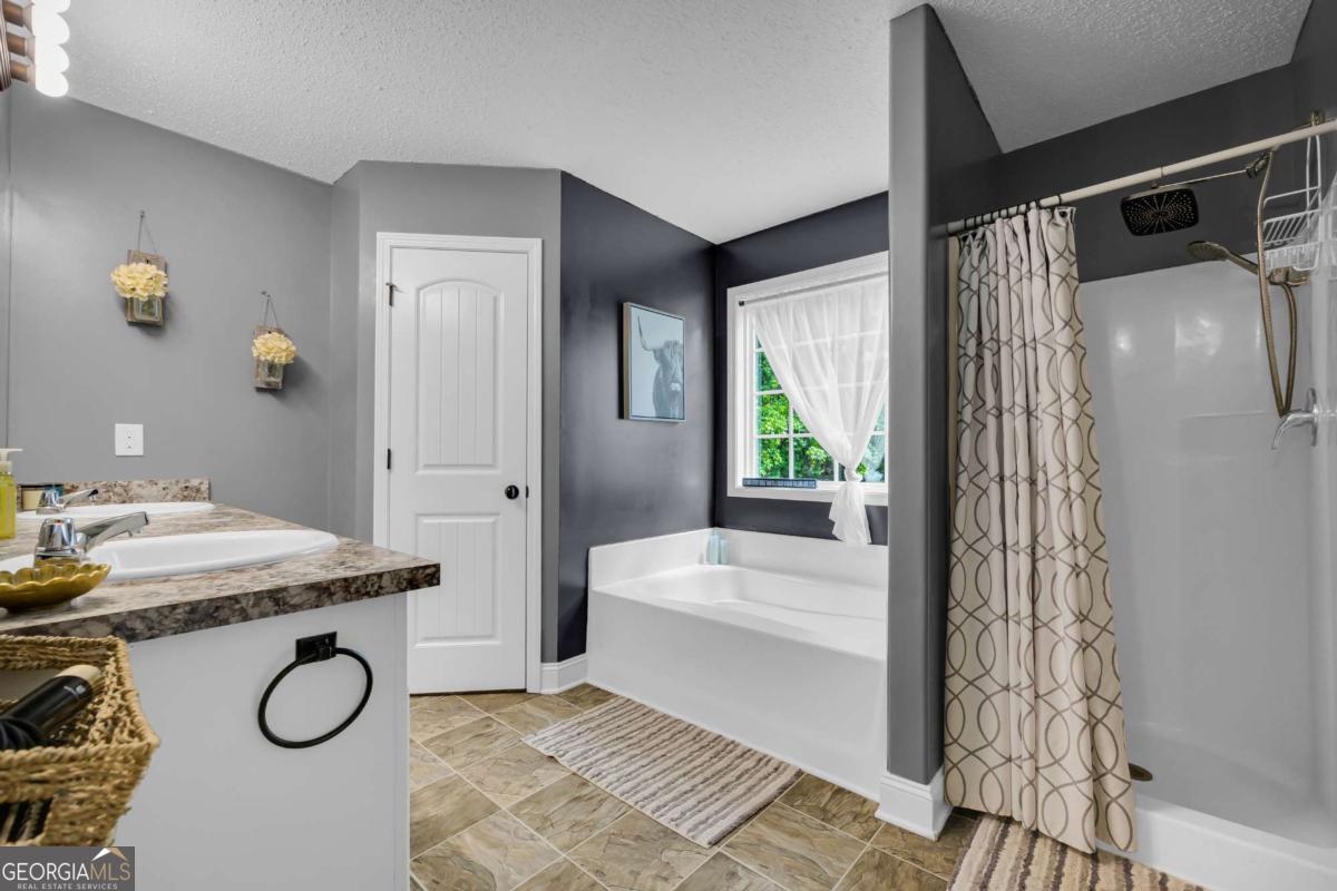 335 Elizabeth Court Colbert, GA 30628 - Photo 19 of 33 a bathroom with a granite countertop sink a toilet and shower