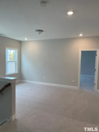 an empty room with windows & cabinet
