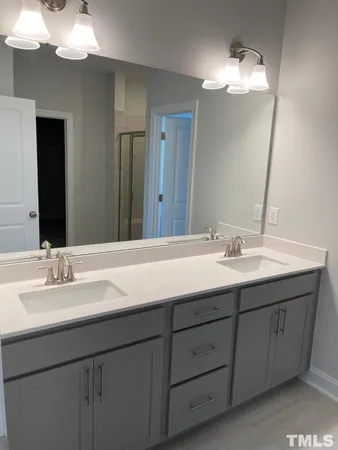 a bathroom with a double vanity sink and a mirror