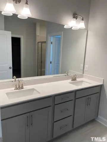 a bathroom with a double vanity sink and a mirror