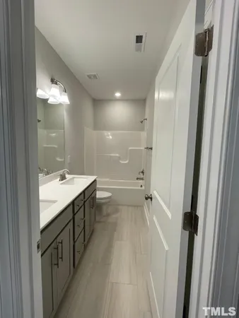 a bathroom with a double vanity sink and mirror with shower