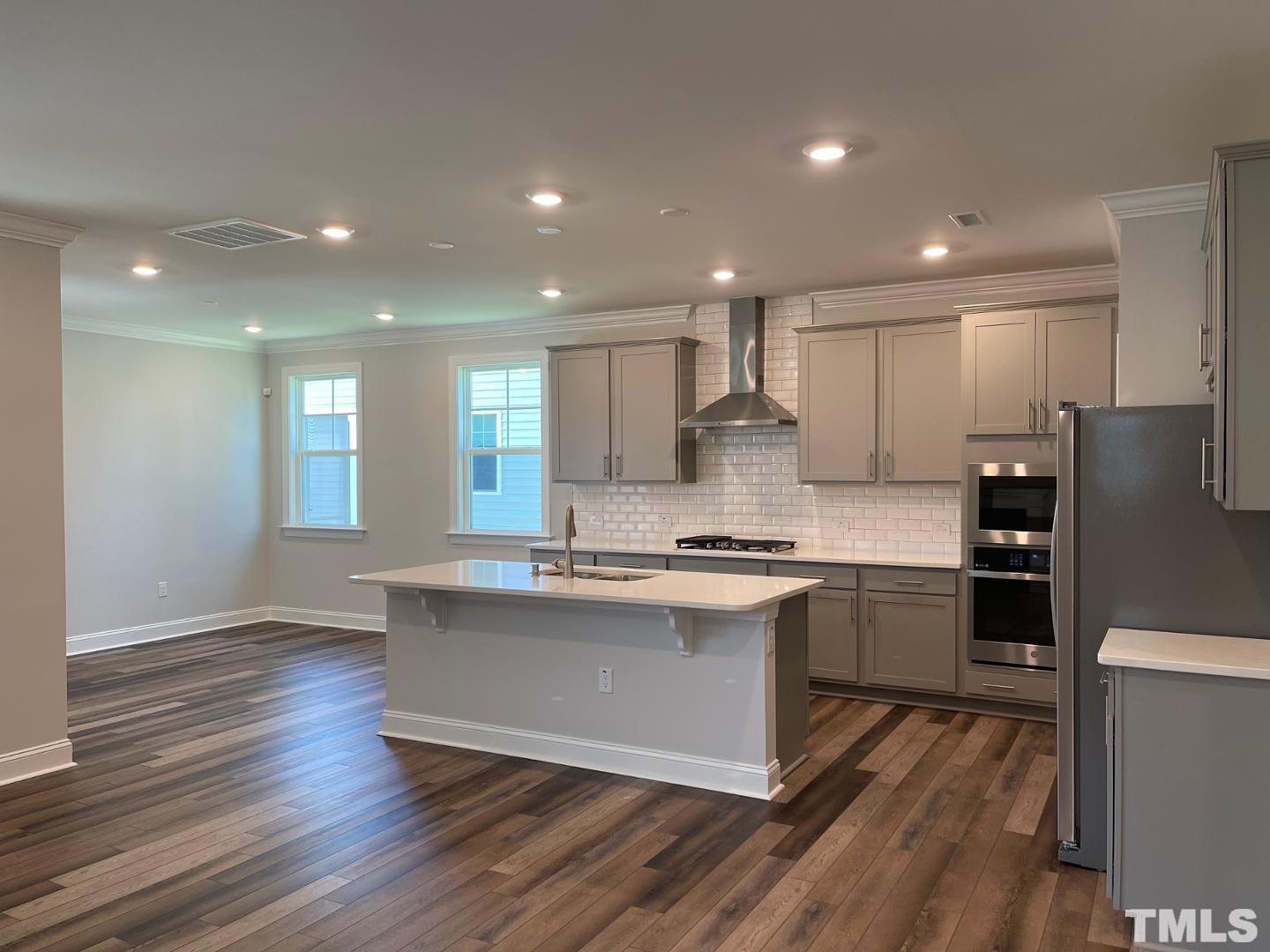168 Edge Of Auburn Boulevard Raleigh, NC 27610 - Photo 5 of 19 a kitchen with stainless steel appliances granite countertop a stove cabinets and wooden floor