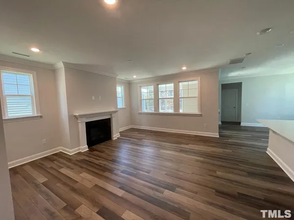 a view of empty room with wooden floor and fireplace
