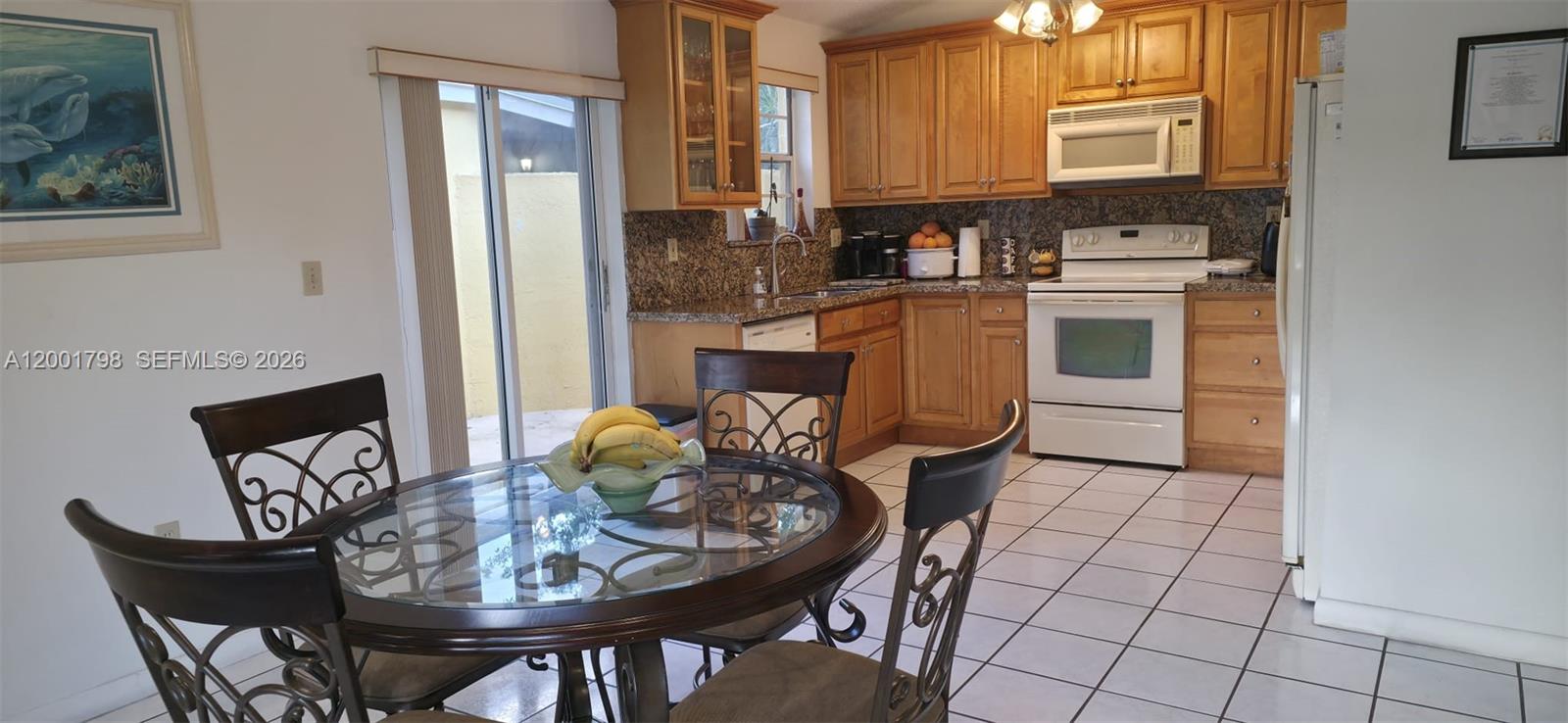 14971 Southwest 75th Terrace Miami, FL 33193 - Photo 9 of 24 a kitchen with a table chairs and a stove