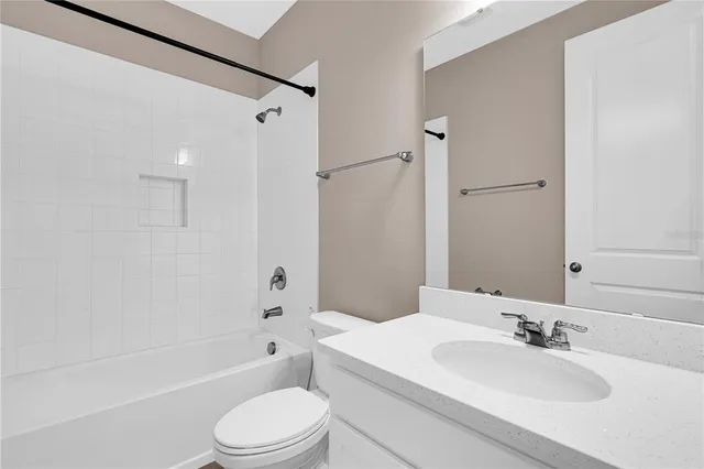 a bathroom with a toilet a sink a mirror and shower