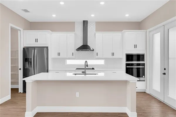 a view of kitchen with stainless steel appliances granite countertop a stove a sink and a refrigerator