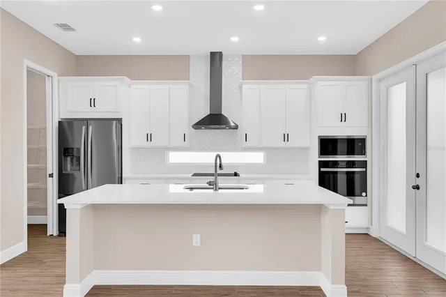 a view of kitchen with stainless steel appliances granite countertop a stove a sink and a refrigerator