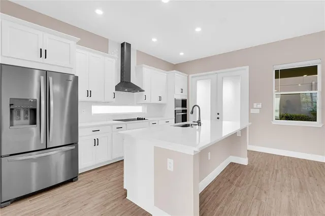 a kitchen with stainless steel appliances a refrigerator sink and cabinets