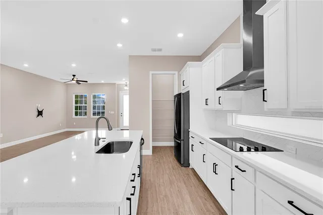 a kitchen with stainless steel appliances a sink a stove a refrigerator and cabinets