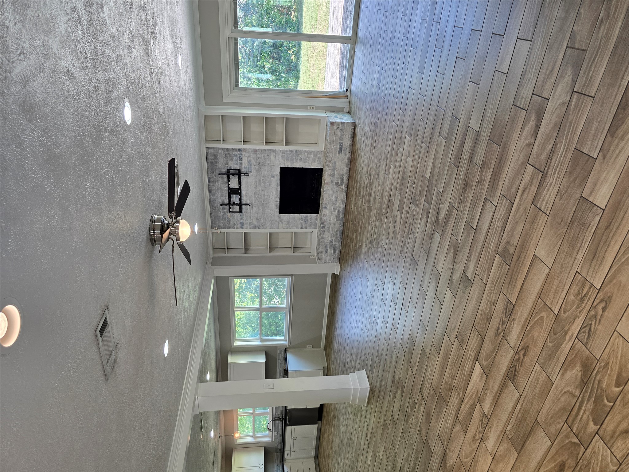205 East Cherokee Drive Harker Heights, TX 76548 - Photo 5 of 23 An inviting open-concept living space features wood-look tile flooring and a cozy fireplace with built-in shelving.