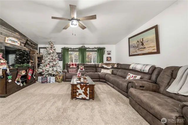 a living room with furniture a ceiling fan and a window