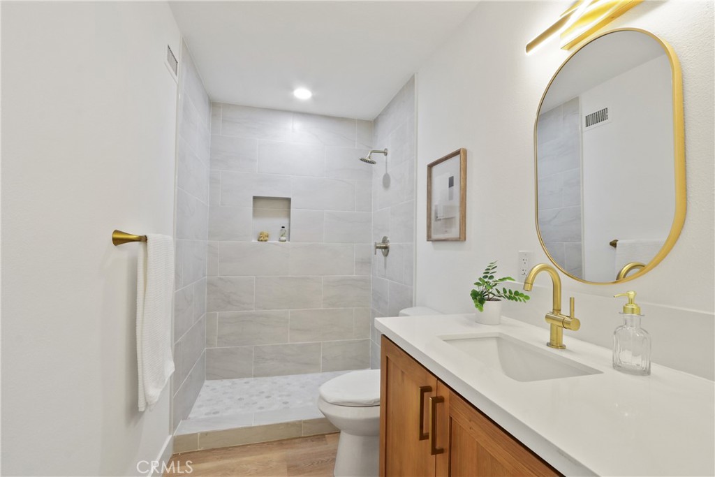 5633 Lakia Drive Cypress, CA 90630 - Photo 15 of 25 a bathroom with a sink a toilet and shower