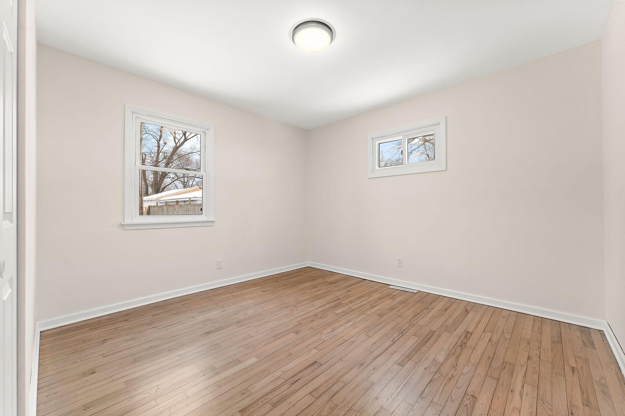 2782 Eleanor Street Portage, IN 46368 - Photo 13 of 20 an empty room with wooden floor and windows