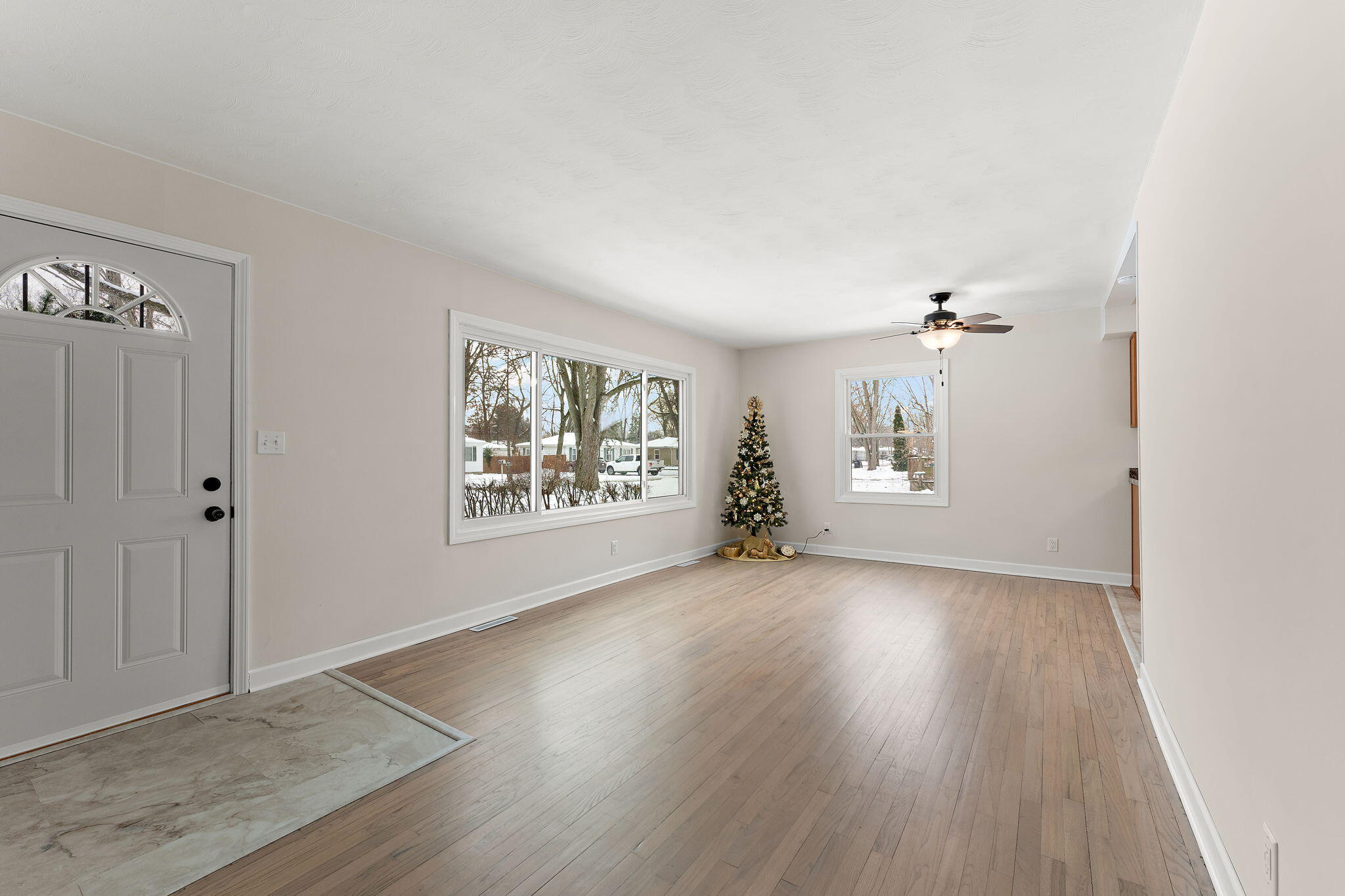 2782 Eleanor Street Portage, IN 46368 - Photo 4 of 20 an empty room with wooden floor chandelier and windows