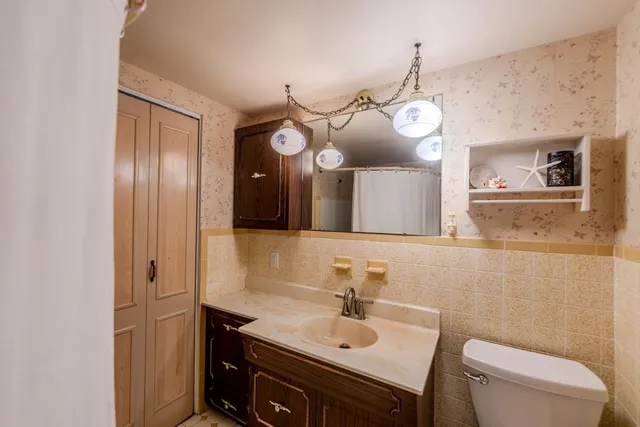 a bathroom with a sink vanity mirror and toilet