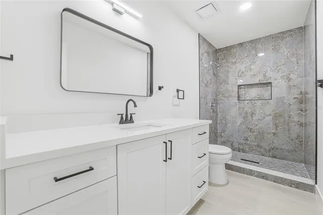 a bathroom with a double vanity sink mirror and toilet
