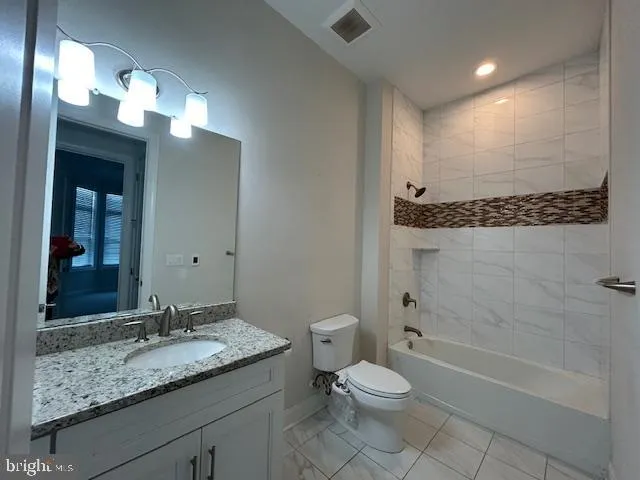 a bathroom with a granite countertop sink a toilet and shower
