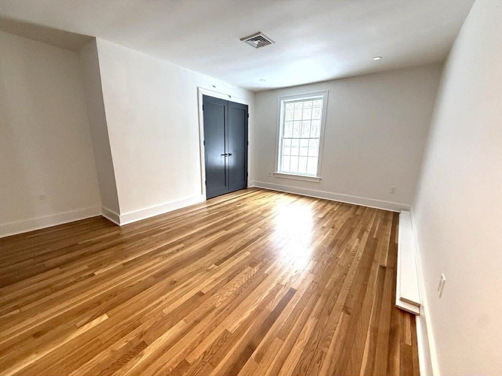 576 Grove Street Framingham, MA 01701 - Photo 23 of 38 a view of an empty room with wooden floor and a window