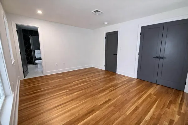 a view of empty room with wooden floor