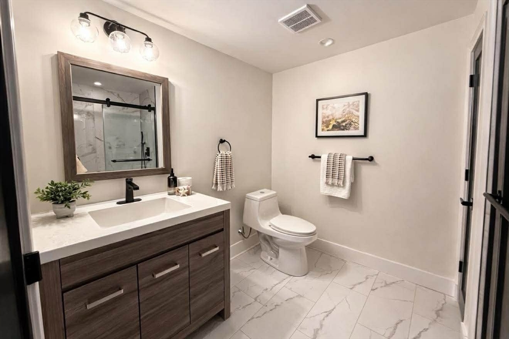 576 Grove Street Framingham, MA 01701 - Photo 28 of 38 a bathroom with a toilet sink and mirror