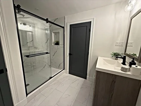 a bathroom with a shower sink and mirror
