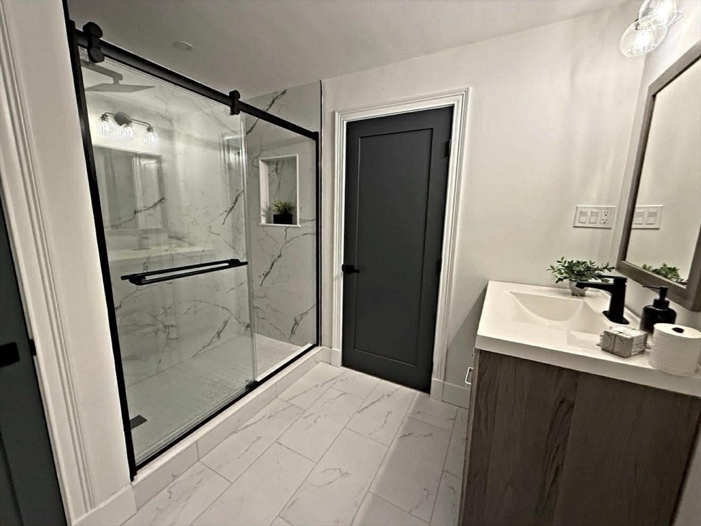 576 Grove Street Framingham, MA 01701 - Photo 29 of 38 a bathroom with a shower sink and mirror