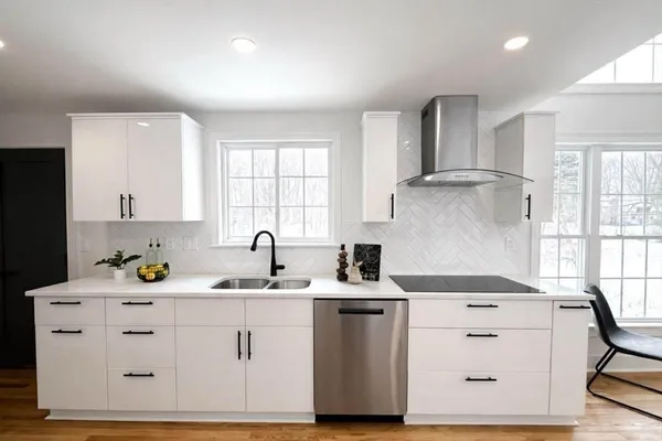 a kitchen with cabinets appliances a sink and a window