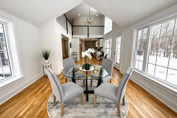 a dining room with furniture a chandelier and wooden floor