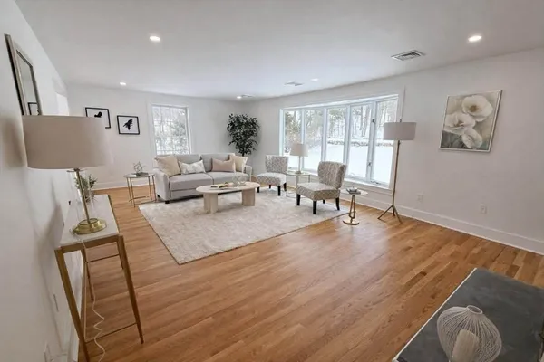 a living room with furniture and a wooden floor