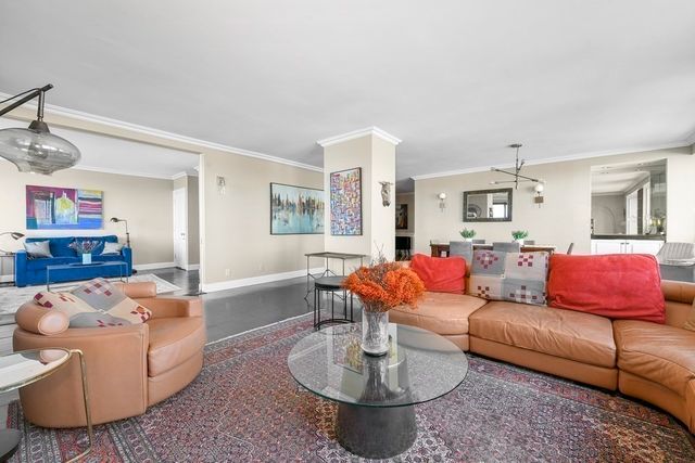 a living room with furniture a large window and wooden floor