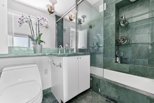 a bathroom with a granite countertop sink a mirror and a shower