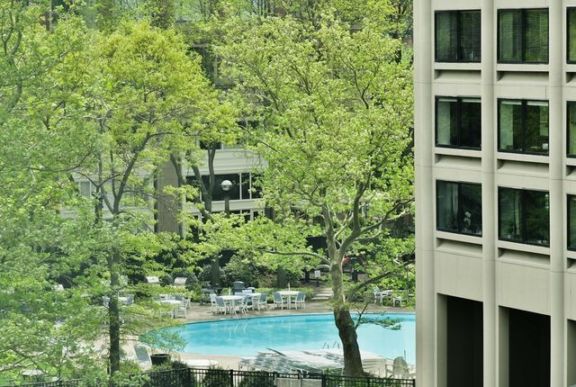a view of a multi story residential apartment building with a yard and potted plants