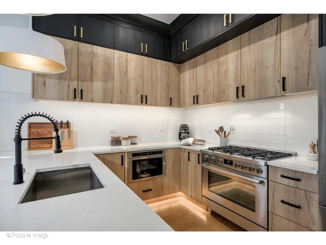 a kitchen with granite countertop a sink a stove and cabinets