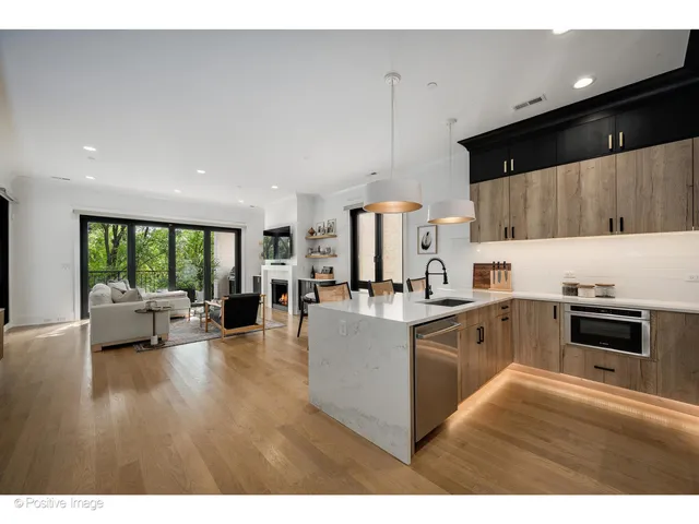 a kitchen with stainless steel appliances granite countertop a stove a sink dishwasher and a microwave oven with wooden floor