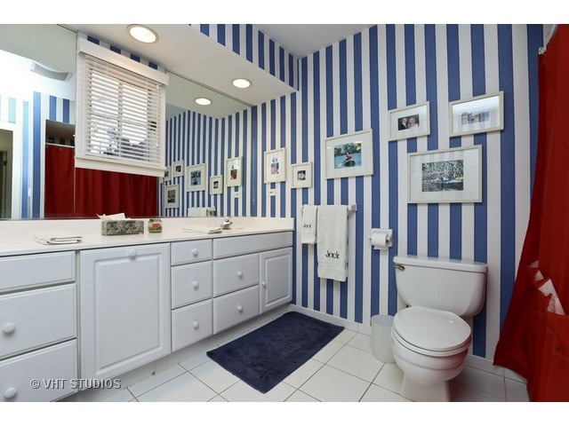 130 Cold Spring Road Barrington, IL 60010 - Photo 14 of 23 a bathroom with a toilet a sink a mirror and a window