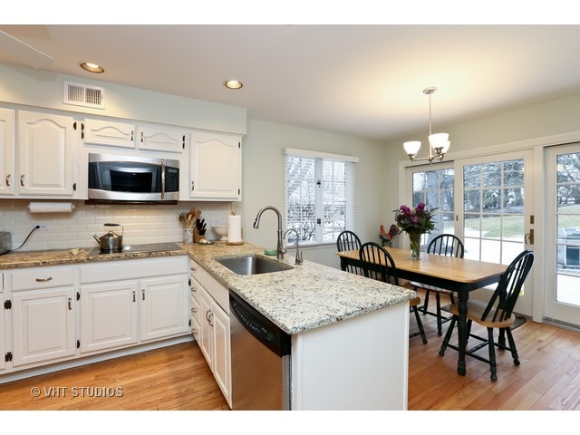 130 Cold Spring Road Barrington, IL 60010 - Photo 5 of 23 a kitchen with granite countertop a table chairs microwave and cabinets