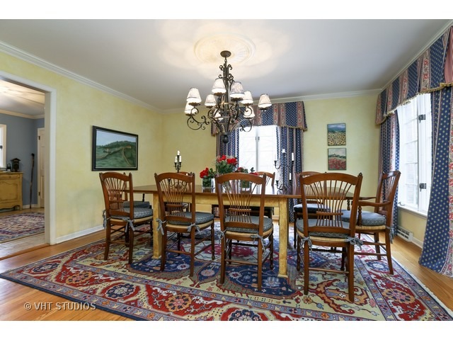 130 Cold Spring Road Barrington, IL 60010 - Photo 6 of 23 a dining room with wooden floor a chandelier a wooden table and chairs