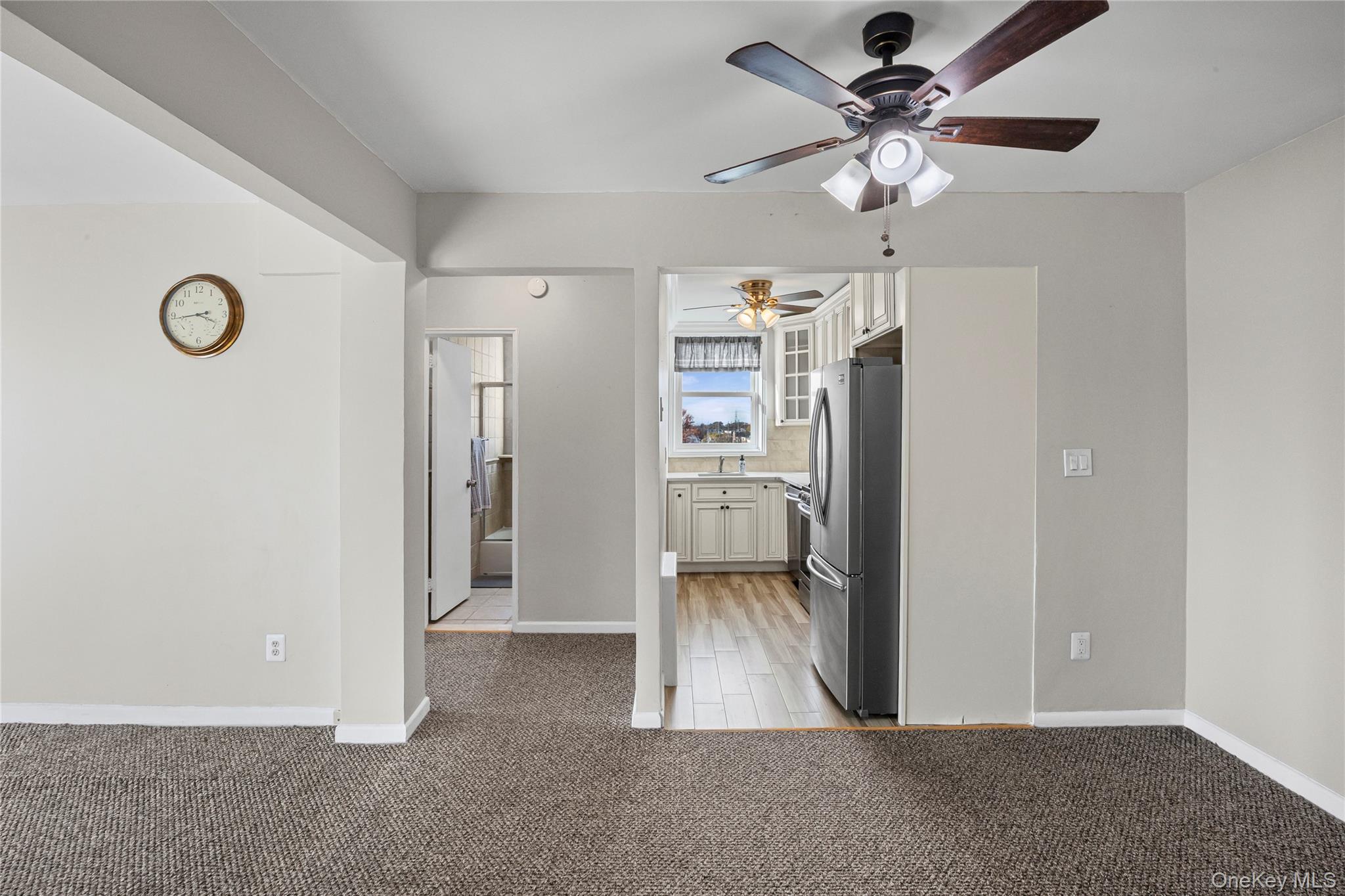 504 Merrick Road, Unit 4E Lynbrook, NY 11563 - Photo 12 of 19 a view of a livingroom with a chandelier fan and a refrigerator