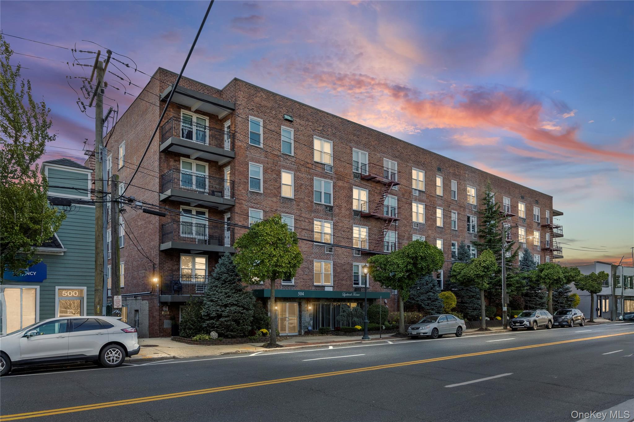 504 Merrick Road, Unit 4E Lynbrook, NY 11563 - Photo 19 of 19 a view of a building and car parked on the side of road
