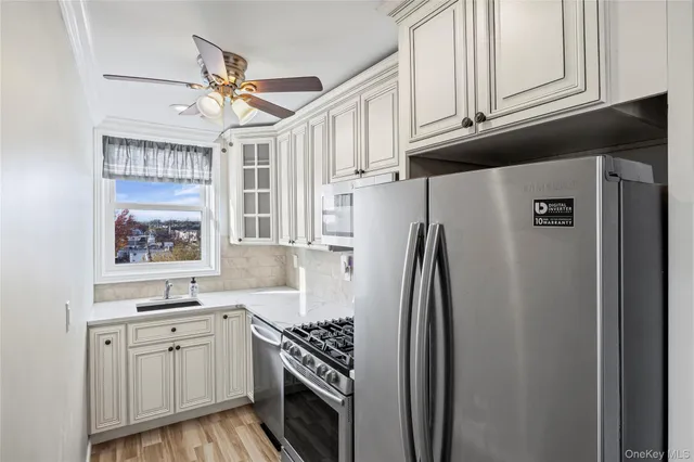 a kitchen with stainless steel appliances granite countertop a refrigerator sink and stove