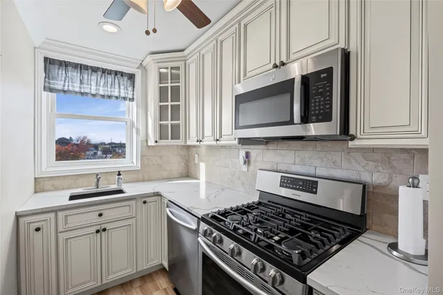 a kitchen with stainless steel appliances granite countertop white cabinets a stove top oven and granite counter tops