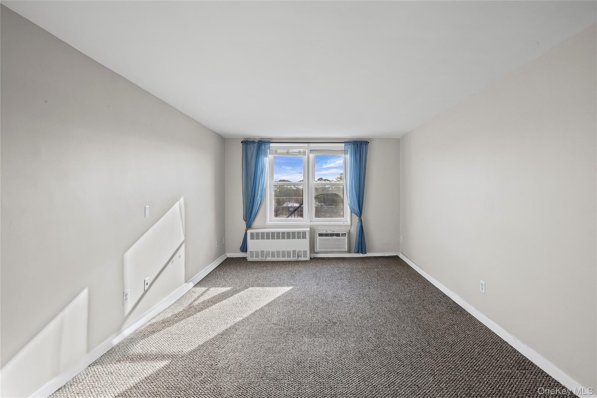 504 Merrick Road, Unit 4E Lynbrook, NY 11563 - Photo 6 of 19 a view of an empty room with a window