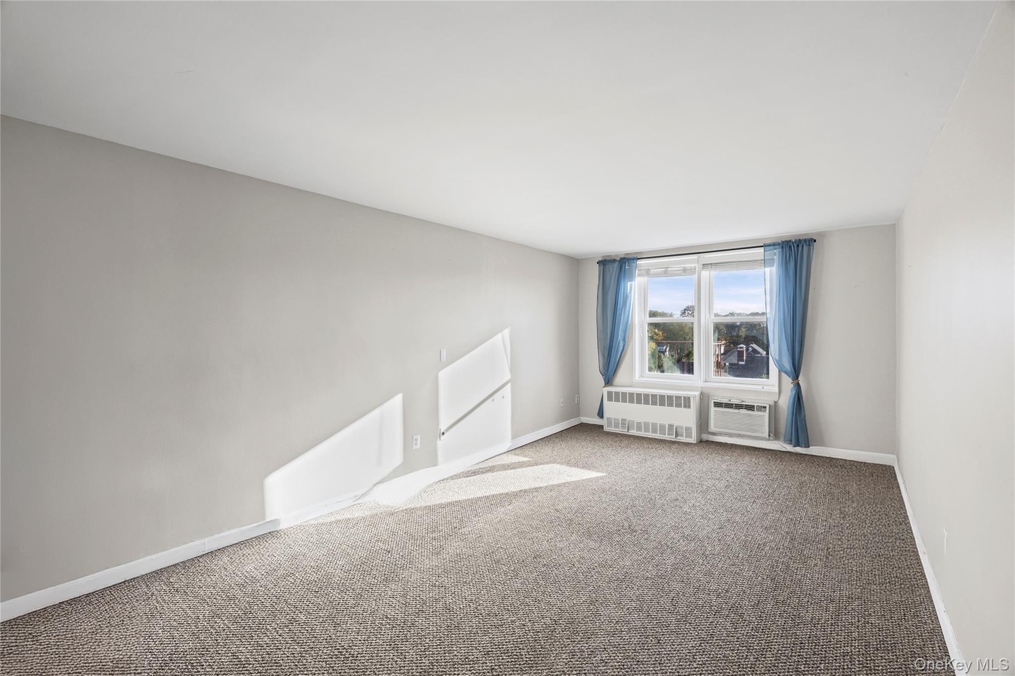 504 Merrick Road, Unit 4E Lynbrook, NY 11563 - Photo 7 of 19 a view of an empty room with a window