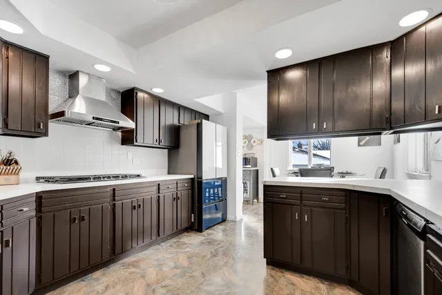 a kitchen with stainless steel appliances granite countertop wooden cabinets a sink and a stove