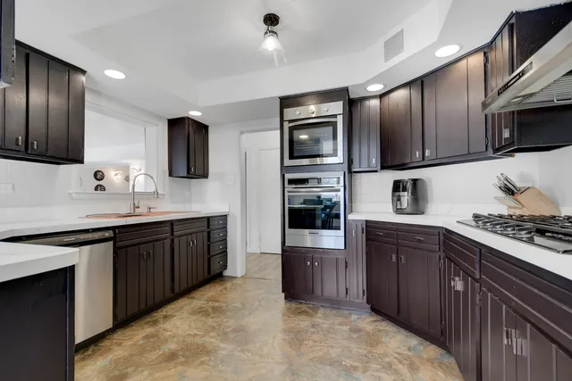 a kitchen with stainless steel appliances granite countertop a stove sink microwave and refrigerator