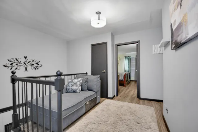 a view of a bedroom with wooden floor and a ceiling fan