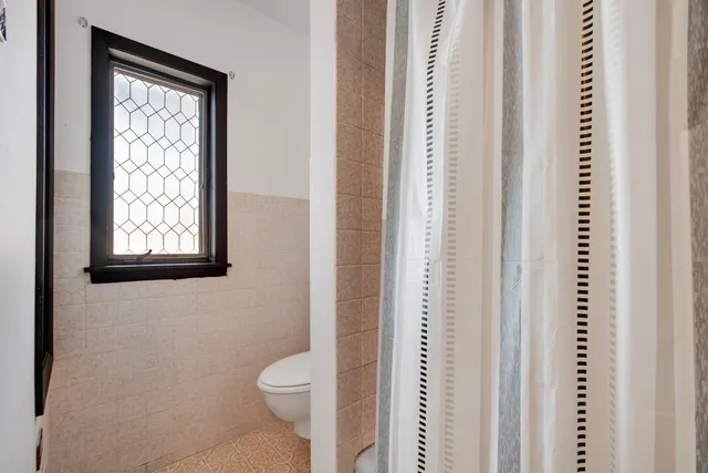 a bathroom with a toilet a sink and a window