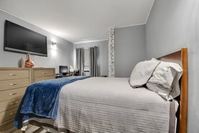 a bedroom with a bed and a flat screen tv